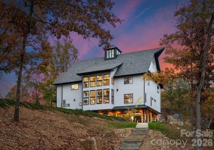 Lake-facing rear elevation showcasing architectural scale and glass-lined living spaces