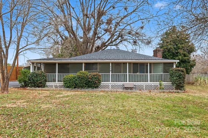 Charming ranch home featuring a full-length screened front porch, perfect for relaxing and enjoying the outdoors year-round.