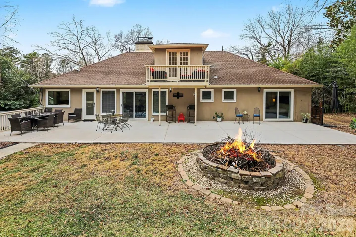 Expansive back patio newly poured (3500 psi), w/CMU Water Sealing (see attachment for details) features french drain along the front of the patio and both sides of the home..  View of your upper level balcony and showing the 3 entrances to your back yard from the main level.