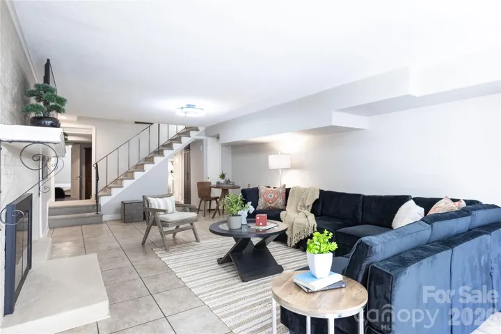 View from exterior door showing the lower level living room, your 4th bedroom on the far left and your kitchenette on thge far right past the stairs to the main level.