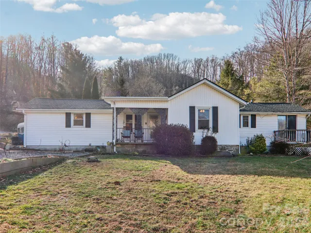 Charming single-level ranch set on nearly one acre, featuring a welcoming front porch, level front yard, and a peaceful, wooded backdrop just minutes from downtown Weaverville.