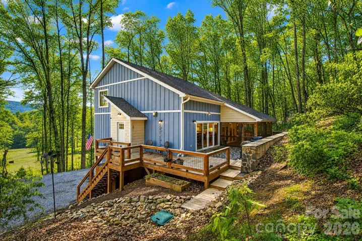 Welcome to 1413 Golf Course Road in Old Fort! Enjoy the ample deck space that flows into the screened in porch year round.