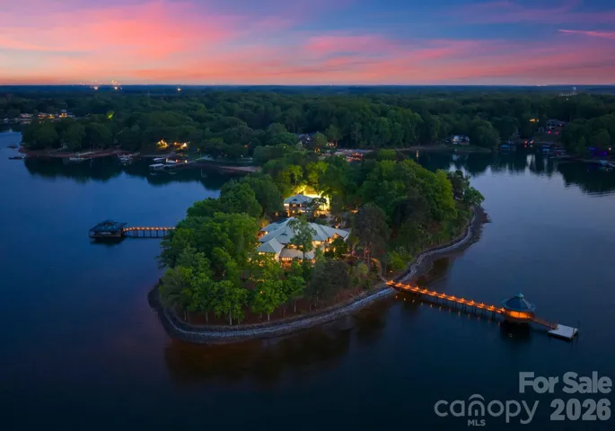 Aerial property view at twilight featuring both docks, main house, guest house, and tennis court.