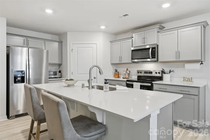 kitchen quartz counter tops, walk-in pantry with wooden shelves, fridge conveys