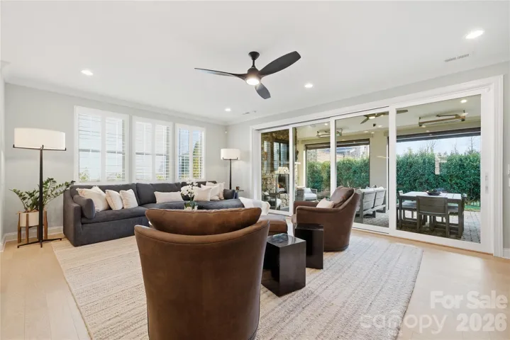 Light and Airy. Plantation Shutters and Stacked Glass Wall Extending Indoor Outdoor Living and Entertaining