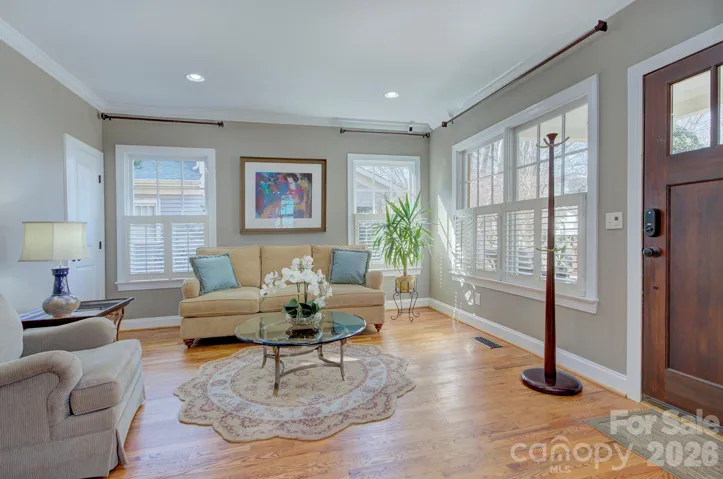 Bright and welcoming formal living room with abundant natural light, hardwood floors, and elegant trim details.