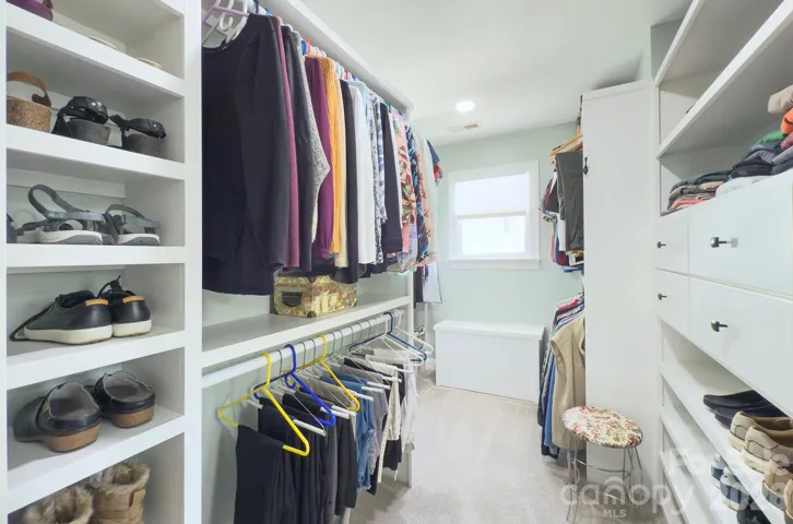 The expansive custom closet features built-in shelving, drawers and abundant hanging space for effortless organization.
