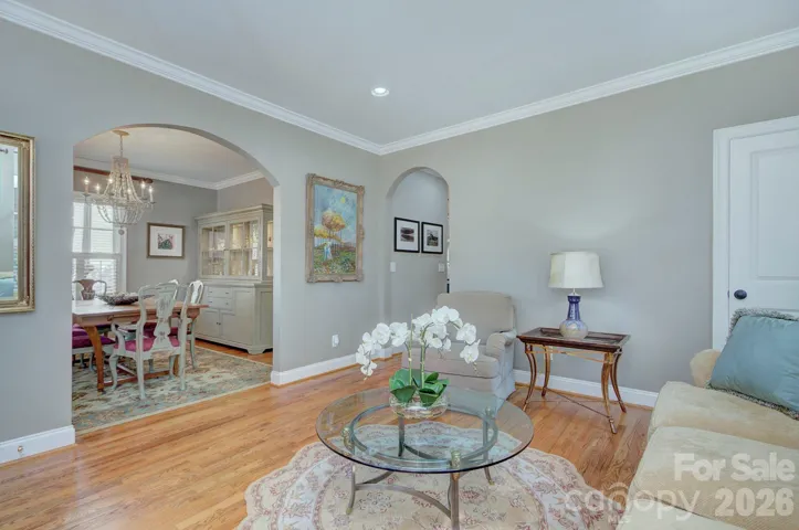 Alternate view of the formal living room showcasing graceful arched openings and seamless flow into the dining area.
