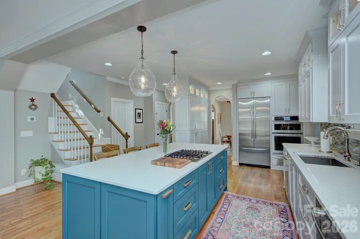 Built-in refrigerator and double ovens framed by custom cabinetry for both beauty and functionality.