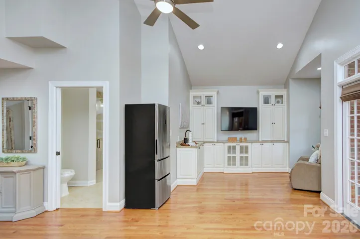 This main-level primary suite features a private kitchenette with custom cabinetry and built-ins, creating a comfortable, self-contained space ideal for extended stays or multigenerational living.