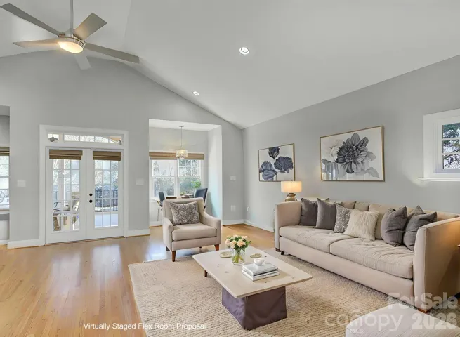 Suggested use of the flex space on the main level. Versatile main-level flex space offers vaulted ceilings, abundant natural light and an inviting open feel, ideal for use as a secondary living area, lounge or media room. Conveniently positioned with direct access toward the screened porch, this space enhances everyday living and entertaining flow. *AI rendering for proposed use of this space only.