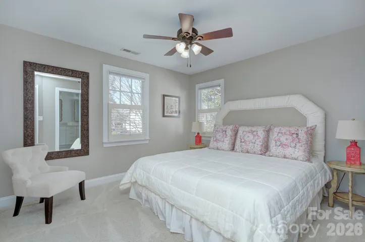 A comfortable secondary bedroom offers soft natural light and flexible space for guests or family.