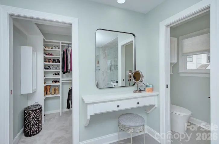 A dedicated dressing vanity area connects the primary bath to the custom walk-in closet for added convenience.