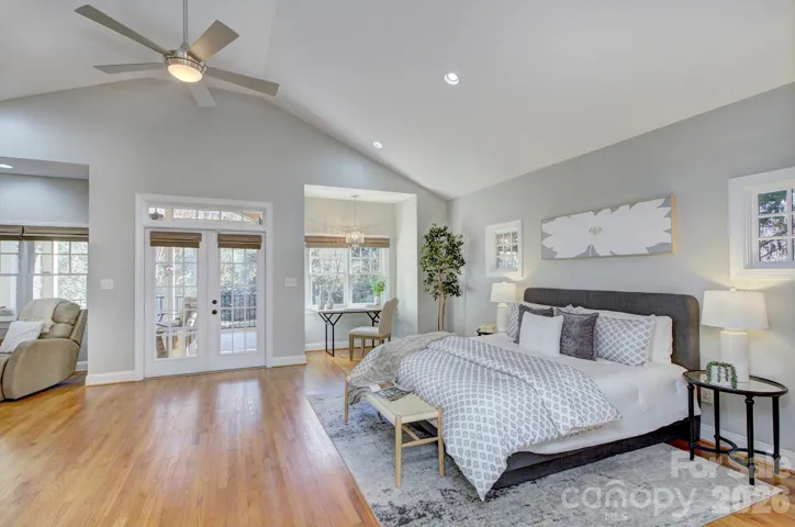 Spacious MAIN LEVEL primary suite/MIL suite/flex room features soaring ceilings, abundant natural light, and private access to the outdoor living area.