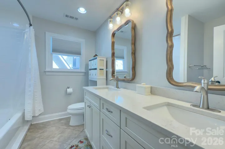The adjoining bath includes a dual vanity and tub/shower combination, ideal for family or guests.