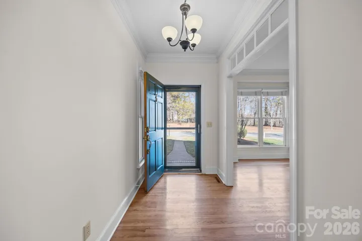  The front door opens to a stunning entry hall paved in rich hardwood flooring that extends a warm welcome and hints at the quality finishes found throughout the residence. 