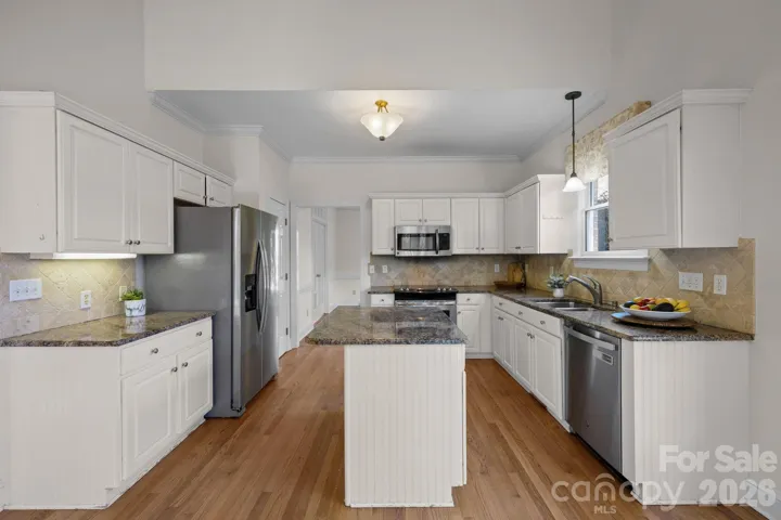 The workspace is equipped with sleek, modern stainless steel appliances, which provide a professional look and complement the overall design. 