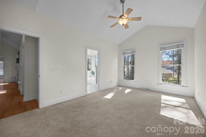 The room's airy atmosphere is immediately enhanced by a stunning vaulted ceiling, which adds a dramatic sense of height and volume to the space. 