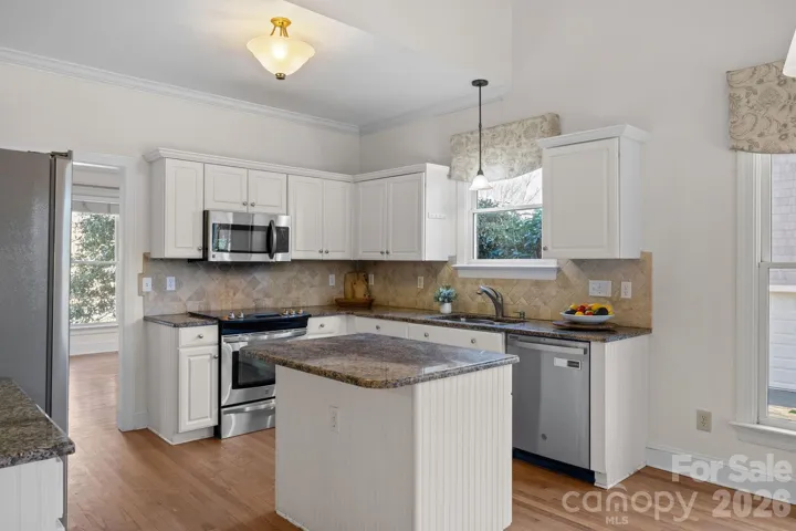 The kitchen boasts a generous island that offers both extensive counter space and comfortable seating, making it perfect for meal prep, casual dining, and gathering.