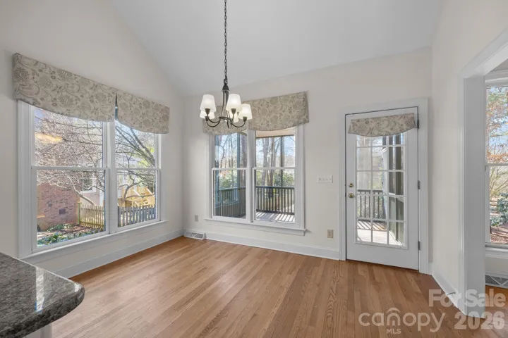 This highly functional dining space offers convenient, seamless access to a screened porch, allowing for effortless indoor-outdoor living, easy entertaining, and a perfect spot to enjoy a morning coffee or evening breeze.