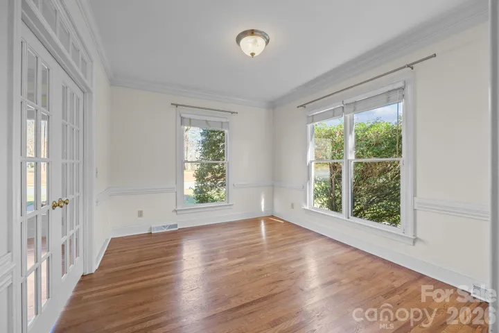 A set of beautiful French doors opens into the dining room which is designed for both elegant entertaining and bright, casual meals featuring a decorative chair rail molding running along the walls, providing a classic accent and defining the space.