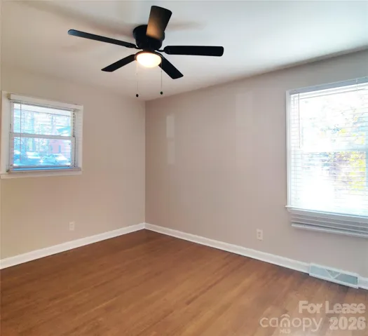 Primary bedroom has hardwood floors and ceiling fan.