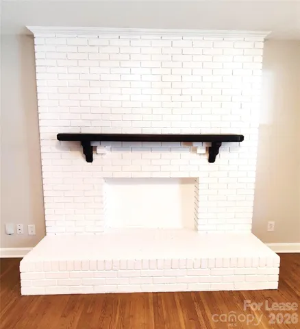 Pretty painted brick decorative fireplace with raised hearth makes for a great focal point!