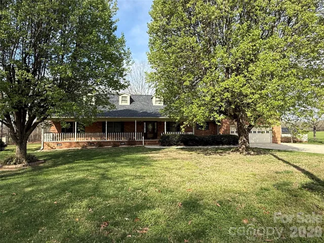 Front of house with large covered front porch 2 car oversized garage attached and 2car detached garage