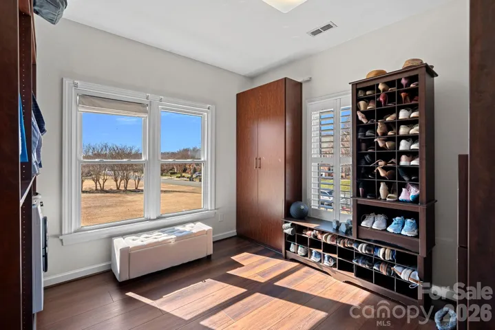 Custom Primary Suite walk in closet with lots of natural light, custom cabinetry and a newly added washer/dryer.