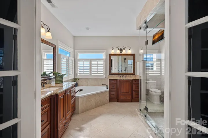 His/Her Gentleman Height vanities with a garden tub and a large walk in shower with STEAM shower.