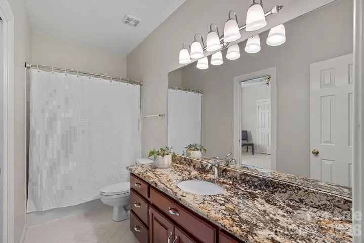 Full bath upstairs adjacent to one of the bedrooms with tub/shower combo and granite countertop vanity.