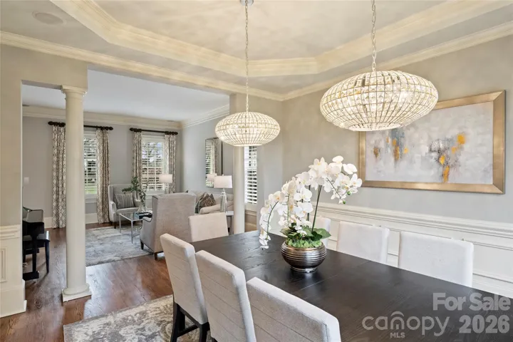 Formal dining room with designer lighting opens to living room