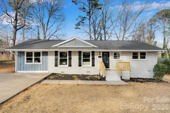 Front Exterior – Freshly updated ranch-style home featuring painted brick, contrasting shutters, and a welcoming front entry with new wood railings for added curb appeal.
