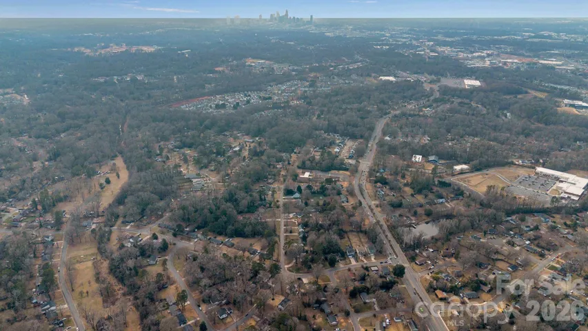 Area Aerial with Skyline – Long-range aerial view with the city skyline visible in the distance, illustrating convenient access to urban amenities.
