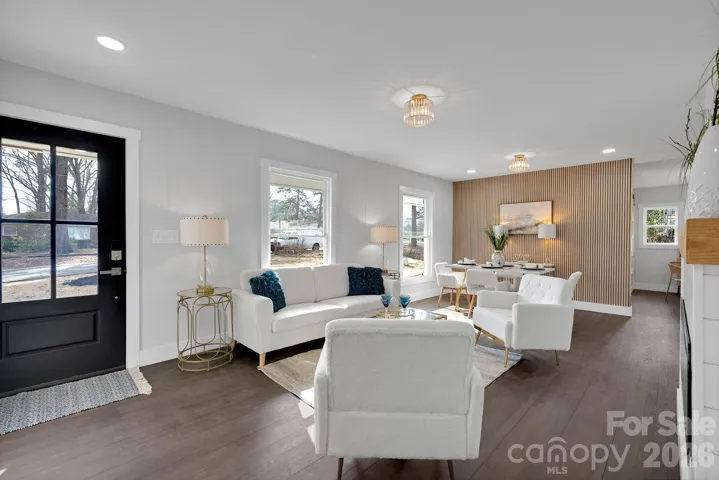 Living Room – Bright, open living area with rich hardwood flooring, abundant natural light, and a sleek modern fireplace, creating a warm and inviting gathering space.