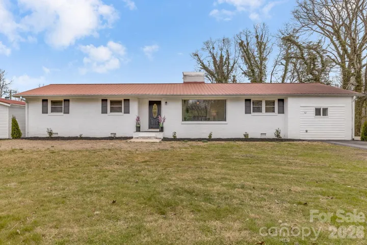 Solid Brick Ranch with metal roof on just over 2 acres! 2 Car garage in back.