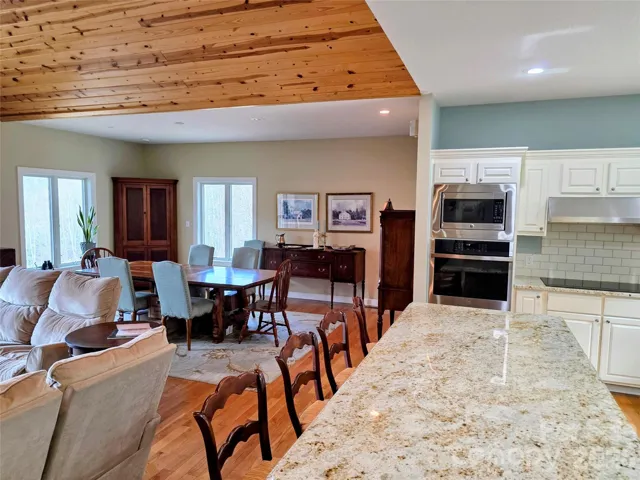 Open floorplan with island, dining area and ovens