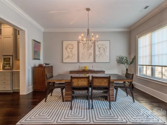 The Formal Dining Room has Extensive Molding, Custom Shade, Hardwood Floors, & Chandelier 