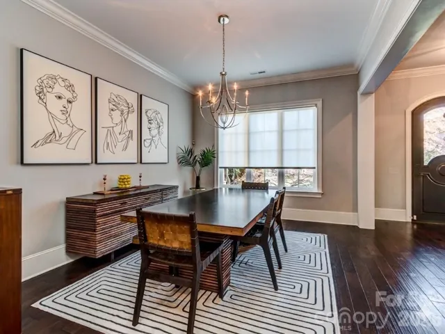 The Formal Dining Room has Extensive Molding, Custom Shade, Hardwood Floors, & Chandelier