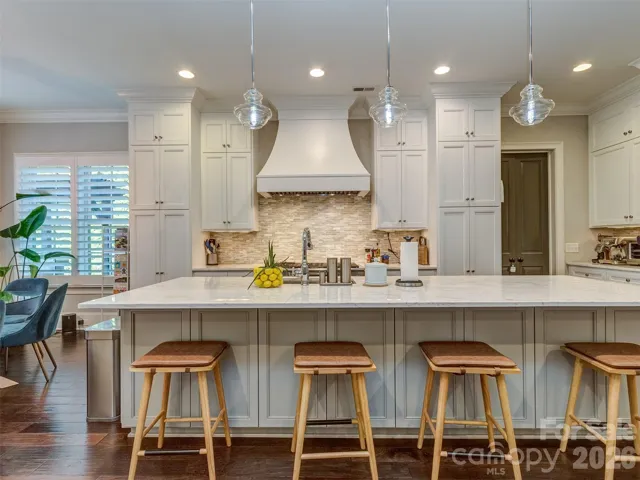 The Gourmet Kitchen Features Quartz Island, Gas Range & Double Oven, Custom Vent Hood, Recessed & Pendant Lighting, Built-In Fridge, Hidden Pantry, & MORE!