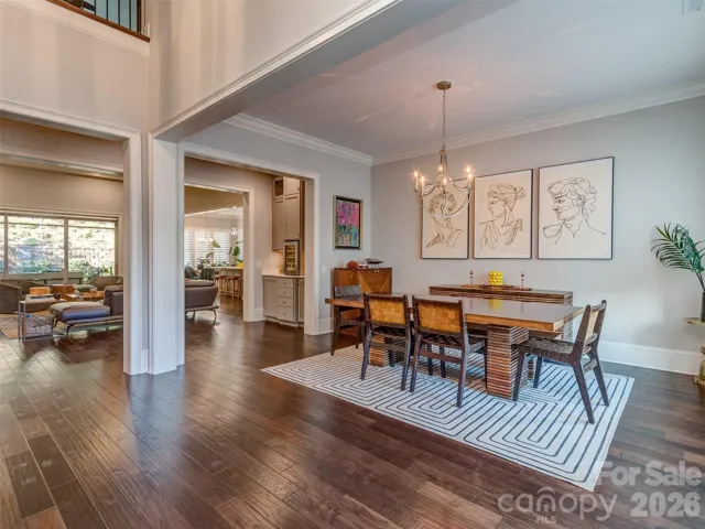 The Formal Dining Room has Extensive Molding, Custom Shade, Hardwood Floors, & Chandelier 