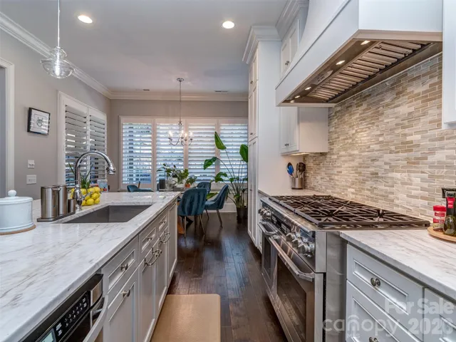 The Gourmet Kitchen Features Quartz Island, Gas Range & Double Oven, Custom Vent Hood, Recessed & Pendant Lighting, Built-In Fridge, Hidden Pantry, & MORE!