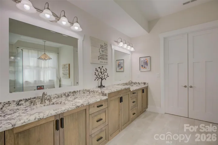 Primary Bath with granite countertops, double bowl vanity, time floors, and walk-in closet.