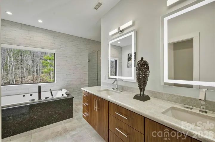 The bathroom in the primary bedroom suite is a tranquil spa-like 