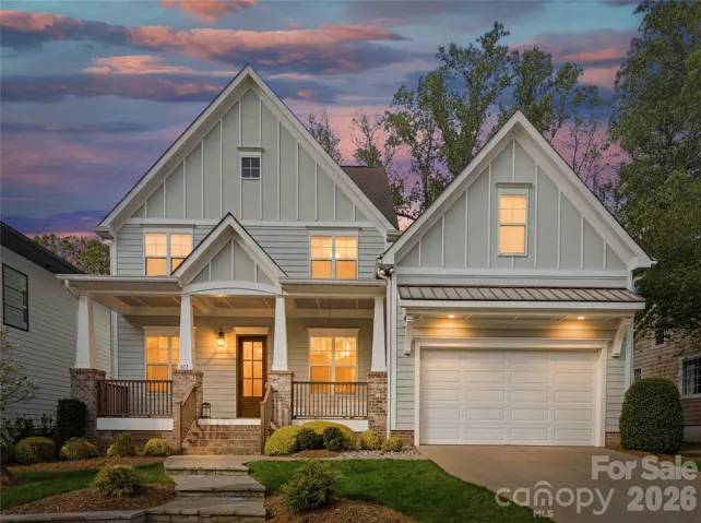 Stunning curb appeal at golden hour. This custom built home welcomes you with timeless architecture, warm lighting, and a charming covered front porch in one of Charlotte’s most desirable neighborhoods.