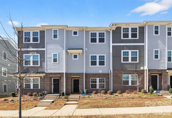 Stunning modern townhome with timeless curb appeal, featuring a beautifully maintained façade and inviting front entrance