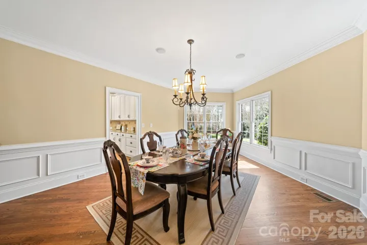 Sophisticated formal dining room featuring classic wainscoting, oversized windows, and a statement chandelier—perfect for memorable dinners and holiday gatherings.