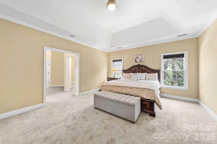 Luxurious owner’s retreat with a tray ceiling, expansive layout, and serene views—offering a peaceful escape at the end of the day.