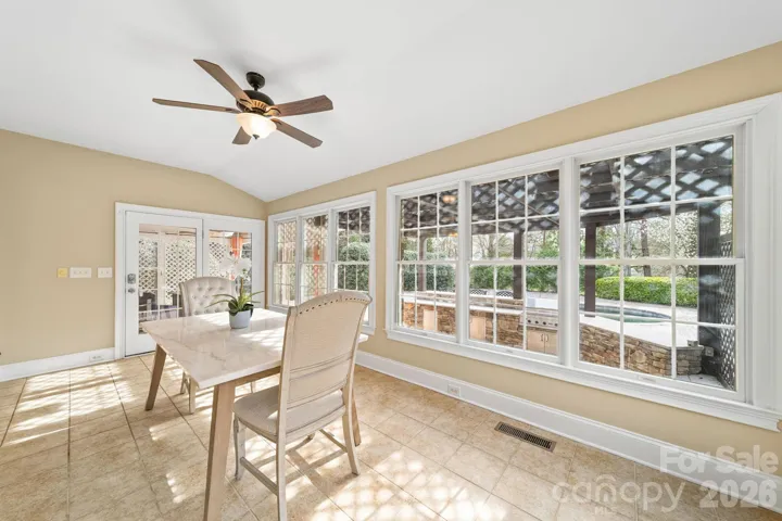 Light-filled breakfast area surrounded by windows, providing picturesque views of the backyard and the perfect space to start your day.