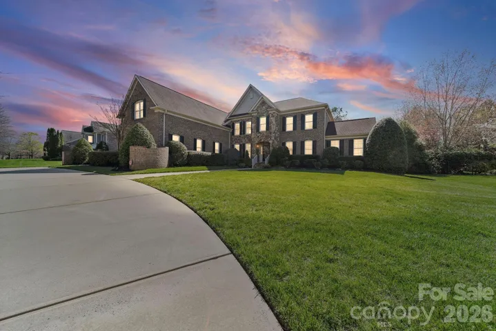 A striking brick and stone estate with impeccable curb appeal, featuring a sweeping driveway and beautifully manicured grounds that create a grand first impression.